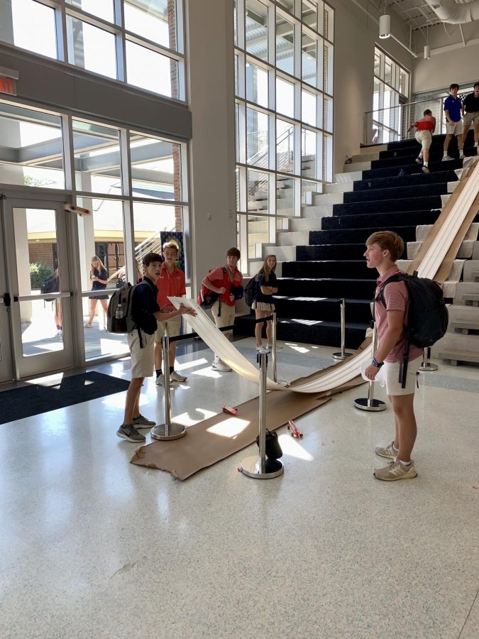 Students race their cars down the ramp.