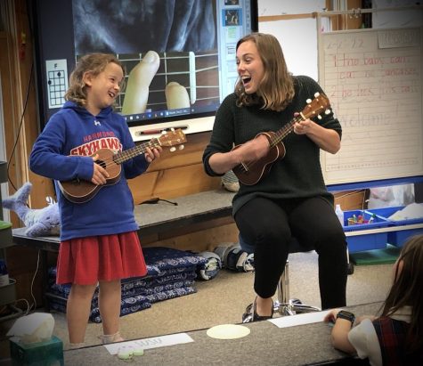 Ms Adams teaches a Lower School music class. She and Susu Barden demonstrate how to play Clementine on the ukulele. 